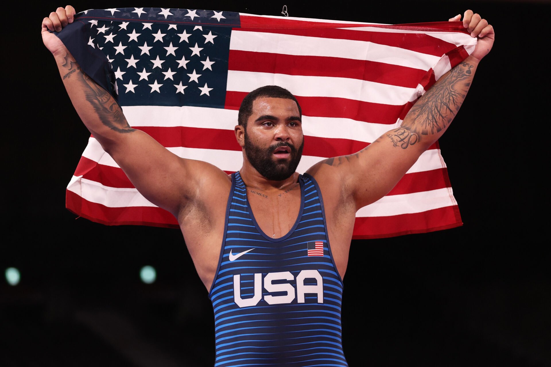 Gable Steveson holding up the American flag at the Olympics