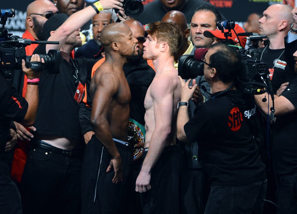 Floyd Mayweather Jr. faces off with Canelo Alvarez at the weigh-ins ahead of their WBC and WBA title fight in 2023