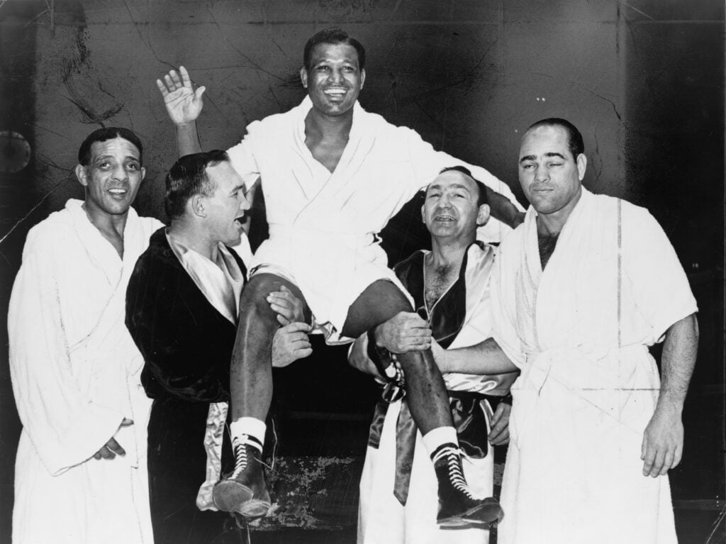 Four boxers carry Sugar Ray Robinson above their heads