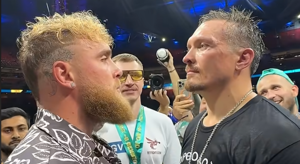 Jake Paul and Oleksandr Usyk face off in the ring after a boxing match
