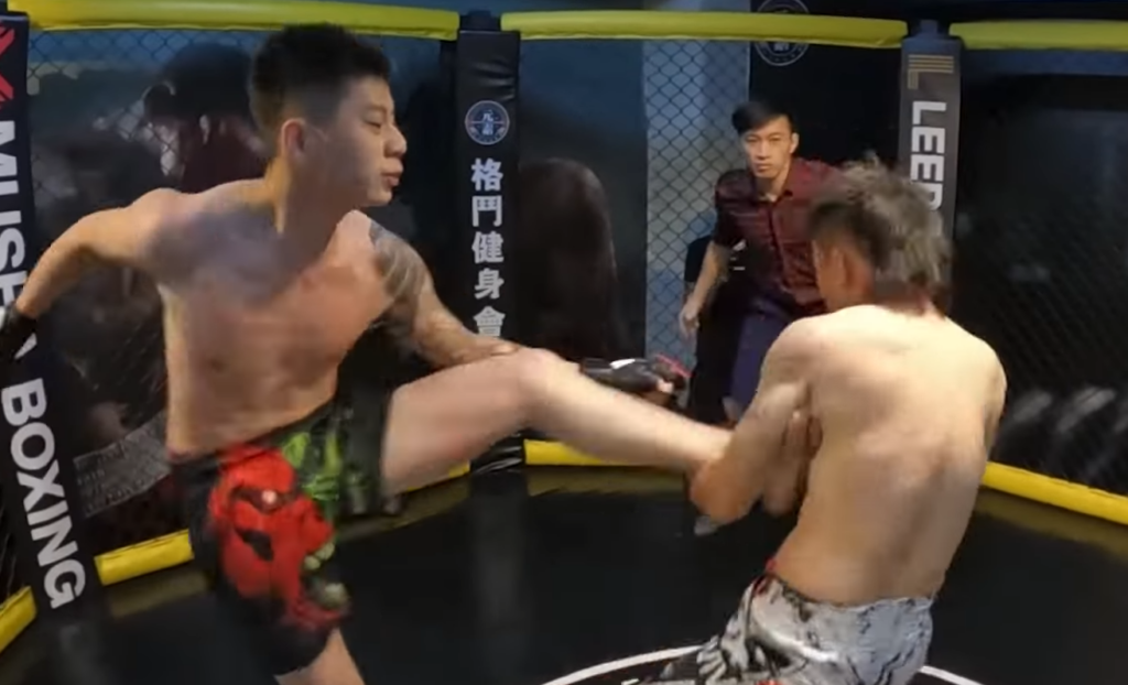 MMA fighter grabbing TKD fighter's leg