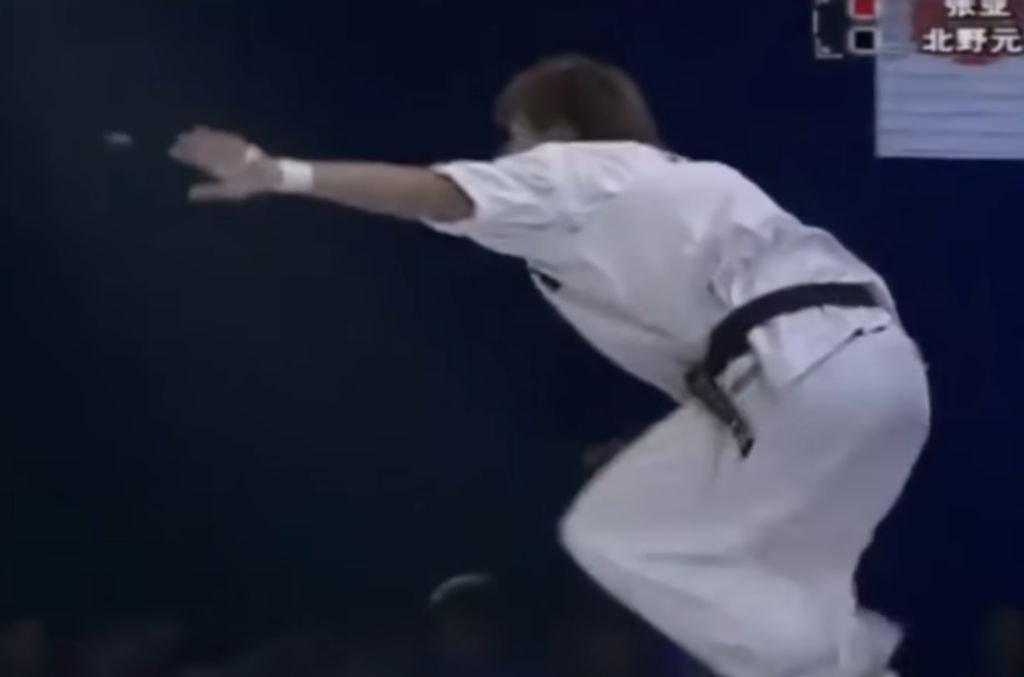 Karate fighter lands safely after being kicked by a Tai Chi practitioner