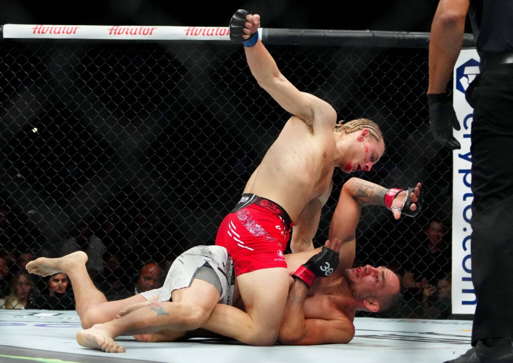 Tony Ferguson (red gloves) fights Paddy Pimblett (blue gloves) during UFC 296 at T-Mobile Arena. 