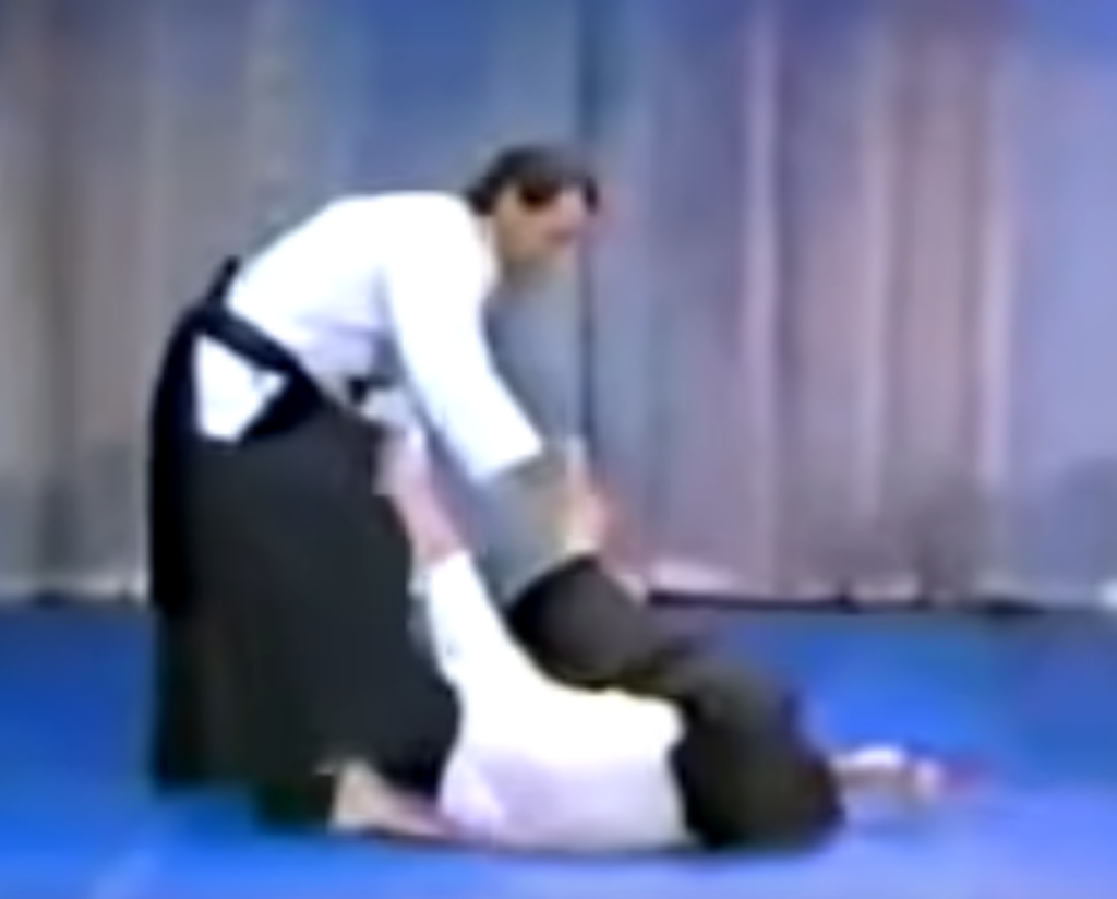 Steven Seagal on the Merv Griffin show in 1982, controlling leg of downed opponent to continue with an attack.
