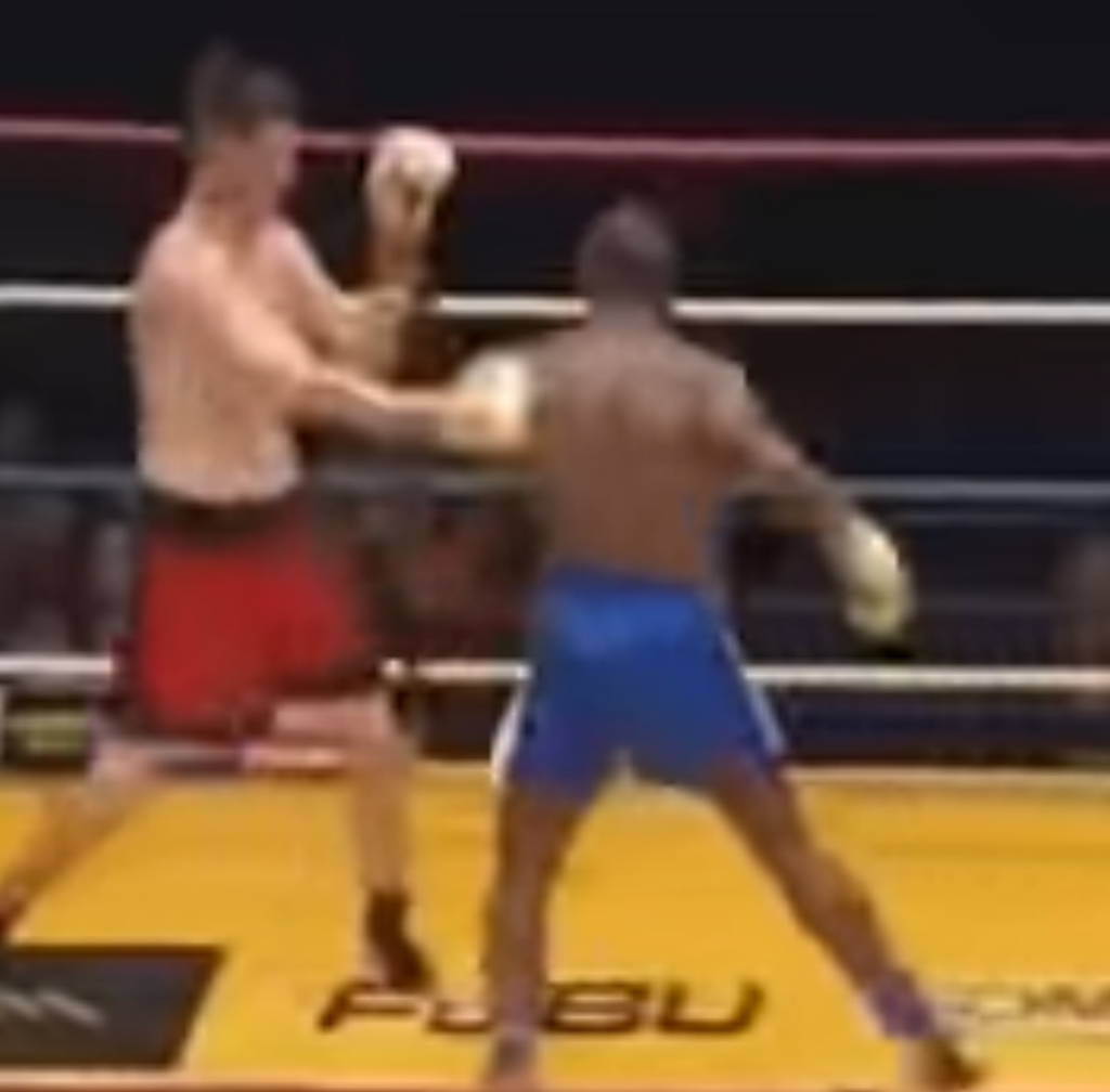 Kickboxer Stanley Nandex positions himself to begin a turn for a spinning heel kick to his opponent's head in a match.