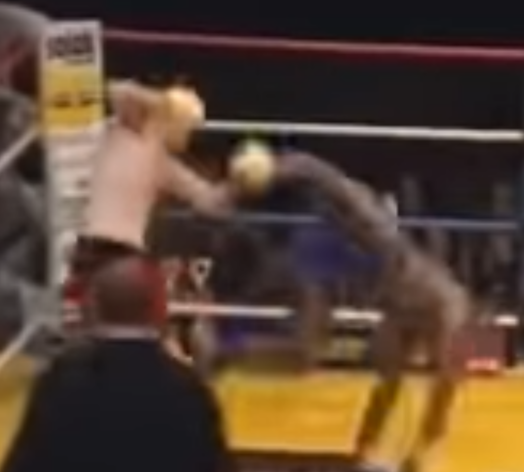 Kickboxer Stanley Nandex lands a kick against his opponent, who bounces off the ropes flailing. 