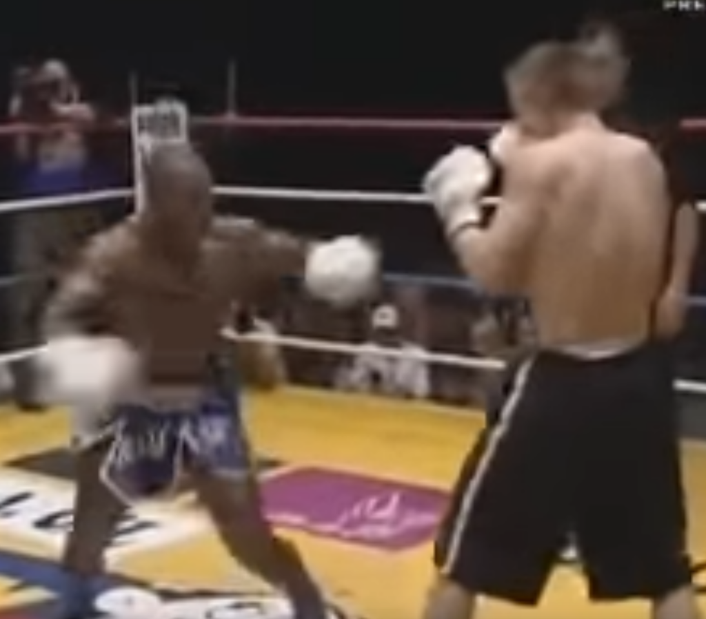 Kickboxer Stanley Nandex begins to turn as he widens his base for a spinning kick.