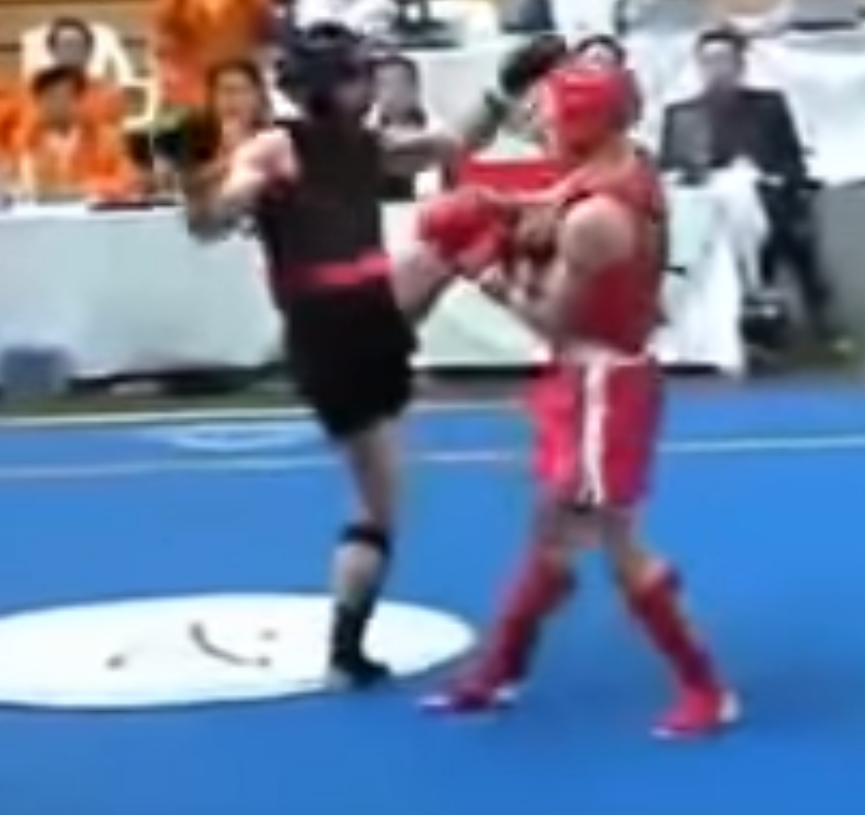 Sanshou competitor has his leg caught while pulling leg back from a headkick.