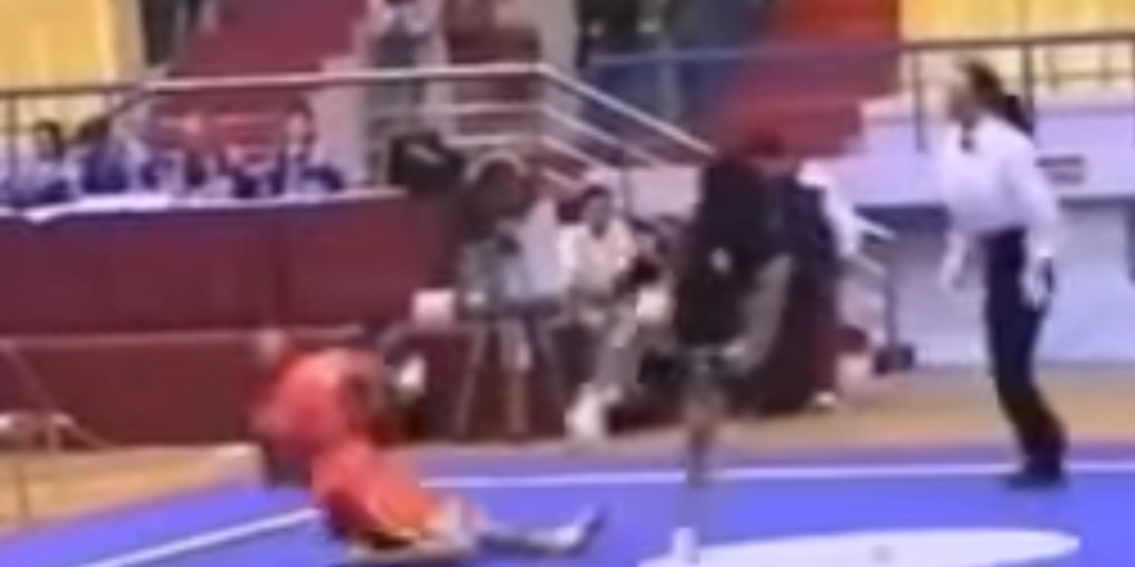 Sanshou competitor falls to the ground after being hit with a side kick to the jaw.